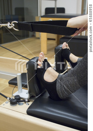 Woman doing pilates machine 65888958
