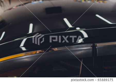 Car detailing - Man applies nano protective coating to the car. Selective focus. 65889175