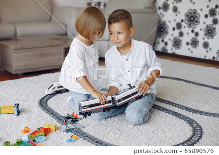 Children playing with lego and toy train in a playing room 65890576