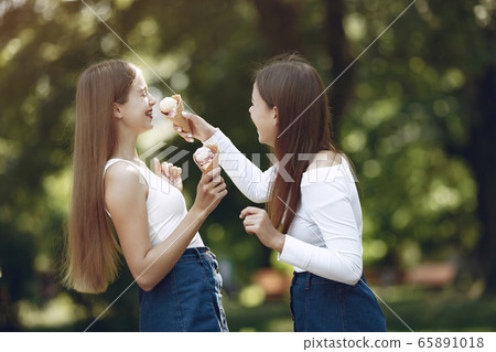 Two elegant and stylish girls in a spring park 65891018