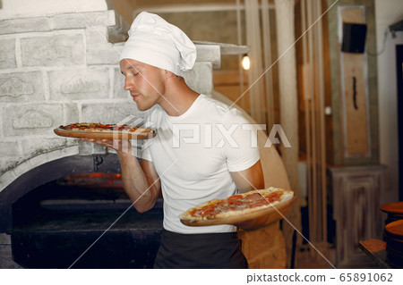 Chef in a white uniform prepare a pizzaa Chef in a white uniform prepare a pizzaa 65891062