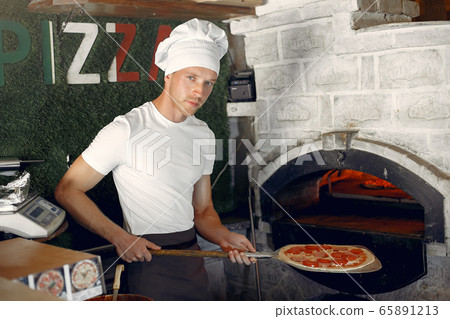 Chef in a white uniform prepare a pizzaa 65891213