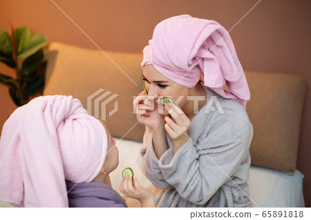Mom and daughter doing spa treatments at home. 65891818