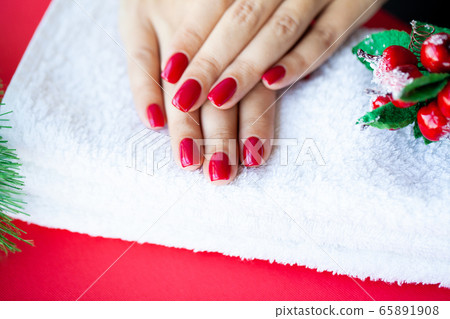 Red Christmas manicure make in beauty studio on Christmas background 65891908