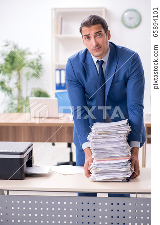 Young male employee making copies at copying machine Young male employee making copies at copying machine 65894101