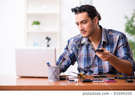 Young male technician repairing mobile phone Young male technician repairing mobile phone 65894200