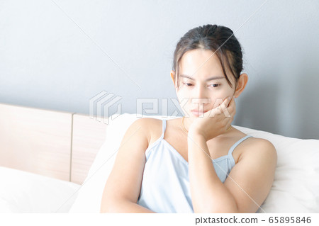 Closeup woman sitting on bed in the bedroom with Closeup woman sitting on bed in the bedroom with 65895846