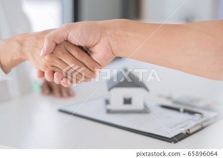 Estate agent in suit sitting in an office desk 65896064