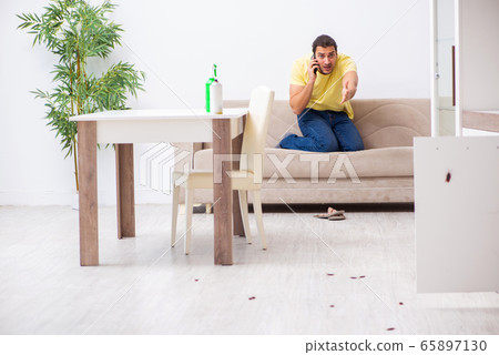 Young man and a lot of cockroaches at home 65897130