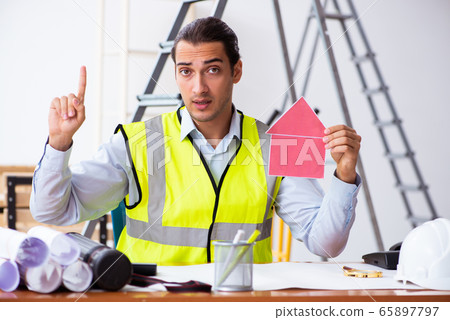 Young male architect working indoors Young male architect working indoors 65897797