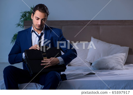 Tired businessman working overtime at home at night 65897917