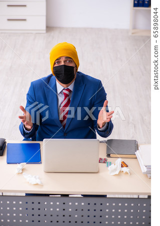 Sick male employee suffering at workplace from coronavirus Sick male employee suffering at workplace from coronavirus 65898044