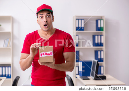Young male courier delivering postbox to the office Young male courier delivering postbox to the office 65898516