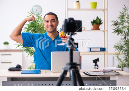 Young male doctor recording video for his blog 65898584