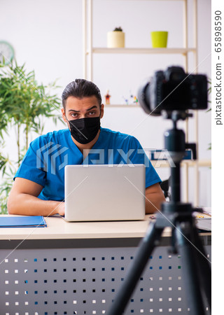 Young male doctor recording video for his blog Young male doctor recording video for his blog 65898590