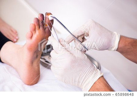 Finger injured woman visiting male doctor traumatologist 65898648