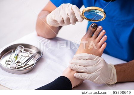 Finger injured woman visiting male doctor traumatologist 65898649