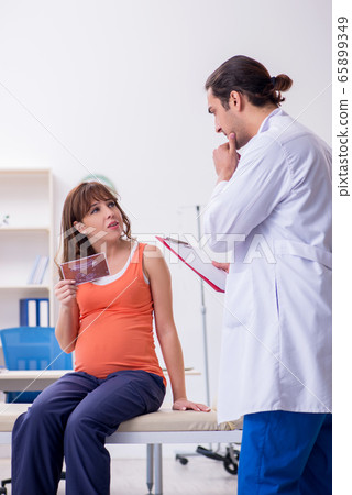 Pregnant woman visiting male doctor gynecologist Pregnant woman visiting male doctor gynecologist 65899349