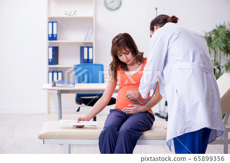 Pregnant woman visiting male doctor gynecologist Pregnant woman visiting male doctor gynecologist 65899356