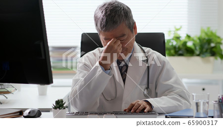 Senior doctor has eyes pain 65900317