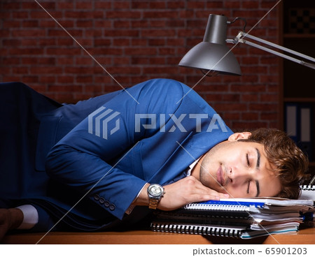 Young businessman working in the office at night 65901203