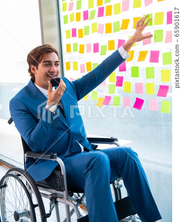 Young handsome man in wheelchair with many conflicting prioritie Young handsome man in wheelchair with many conflicting prioritie 65901617