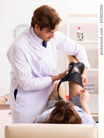 Young female patient visiting male doctor traumatologist 65902000