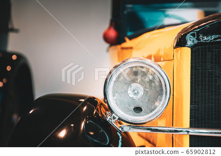 Close Headlamp Of Yellow Retro Vintage Oldtimer Car Close Headlamp Of Yellow Retro Vintage Oldtimer Car 65902812