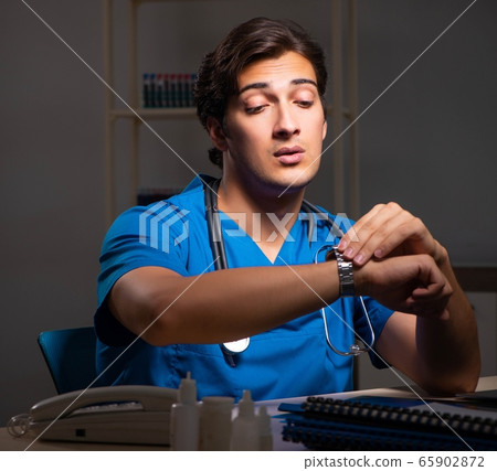 Young handsome doctor working night shift in hospital Young handsome doctor working night shift in hospital 65902872
