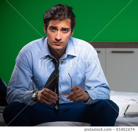 Young businessman under stress in the bedroom at night Young businessman under stress in the bedroom at night 65902874