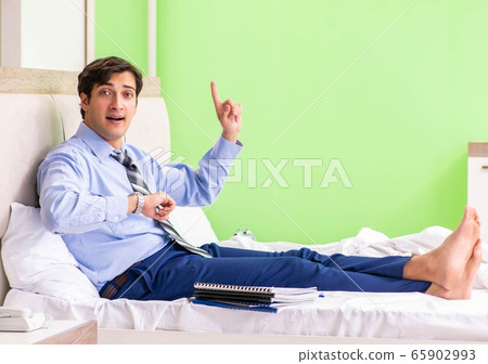 Businessman working overtime in hotel room 65902993