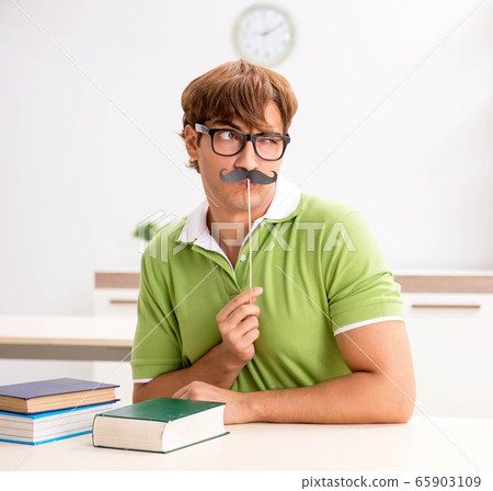 Student with fake moustache reading book 65903109
