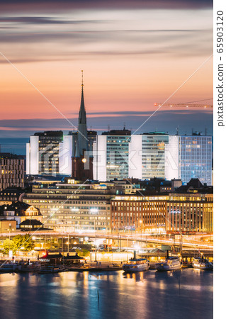 Stockholm, Sweden. View Of St. Clara Or Saint Klara Church And Houses In Twilight Dusk Lights. Evening Night Lighting Stockholm, Sweden. View Of St. Clara Or Saint Klara Church And Houses In Twilight Dusk Lights. Evening Night Lighting 65903120