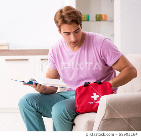 Sick man at home with first aid kit 65903164