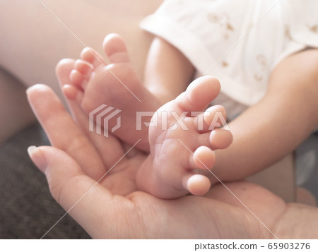 可愛的身體部位，讓剛出生的嬰兒將腳放在母親的手掌上 65903276
