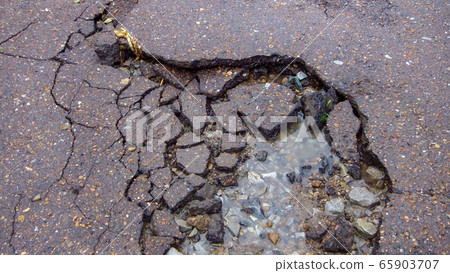 Water erosion of the road. Broken asphalt Water erosion of the road. Broken asphalt 65903707