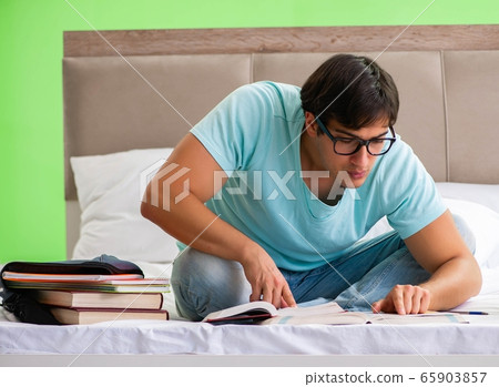 Student preparing for exams at home in bedroom sitting on the be Student preparing for exams at home in bedroom sitting on the be 65903857