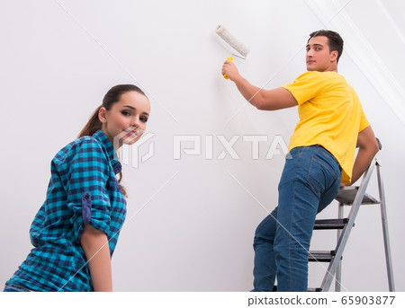 Young couple painting wall at home Young couple painting wall at home 65903877