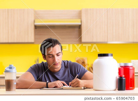 Young man blogging about food supplements Young man blogging about food supplements 65904703