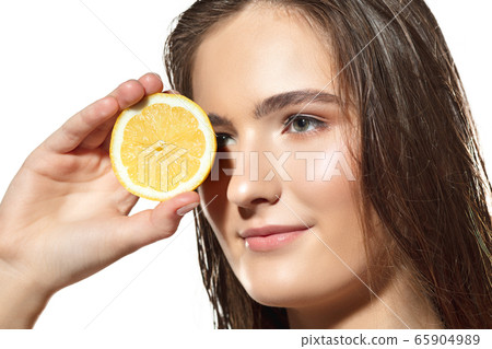 Citrus. Close up of beautiful female face with lemon slices over white background. Cosmetics and makeup, natural and eco treatment, skin care. Citrus. Close up of beautiful female face with lemon slices over white background. Cosmetics and makeup, natural and eco treatment, skin care. 65904989