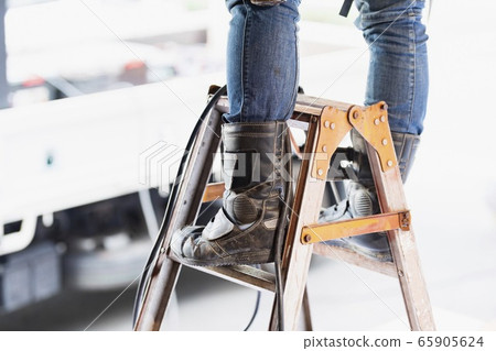 A craftsman who works on a stepladder 65905624