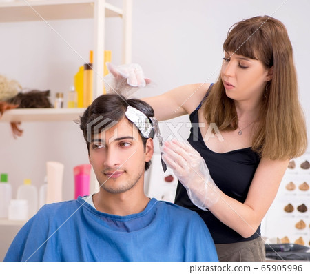 Young attracrive man visiting female barber 65905996