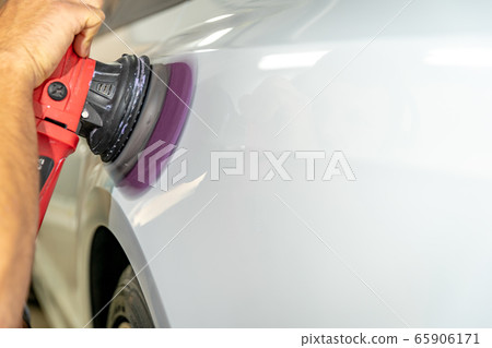 polishing the car body with a manual automatic grinder with wax and polishing paste polishing the car body with a manual automatic grinder with wax and polishing paste 65906171