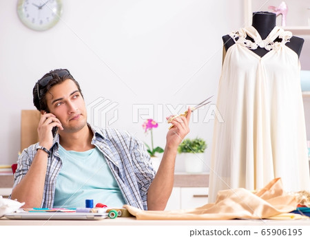 Young handsome tailor working in his workshop Young handsome tailor working in his workshop 65906195
