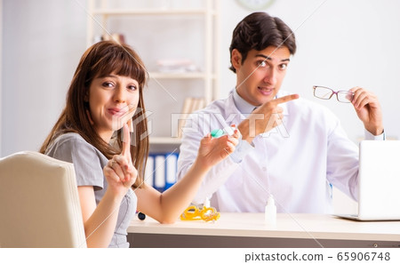 Young woman visiting male doctor ophthalmologist in hospital Young woman visiting male doctor ophthalmologist in hospital 65906748