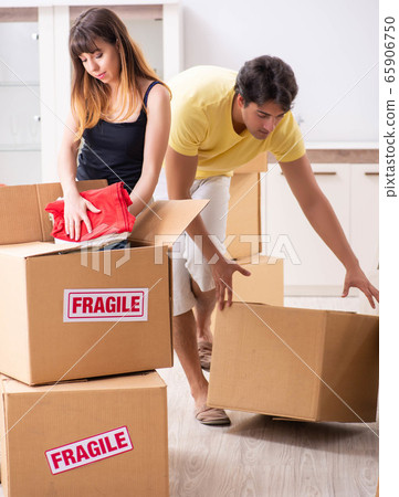 Young couple moving to new flat with fragile things Young couple moving to new flat with fragile things 65906750