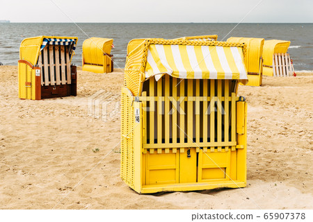 Sandy beach and typical hooded beach chairs in Cuxhaven in the North Sea coast 65907378