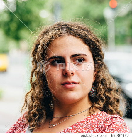 Headshot portrait of confident beautiful young woman with curly hair 65907382