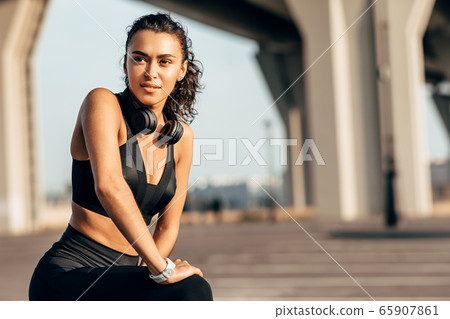 Beautiful fit woman stretching her legs before training Beautiful fit woman stretching her legs before training 65907861