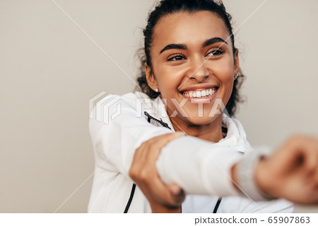 Close up of smiling sports woman warming up her hand before training Close up of smiling sports woman warming up her hand before training 65907863